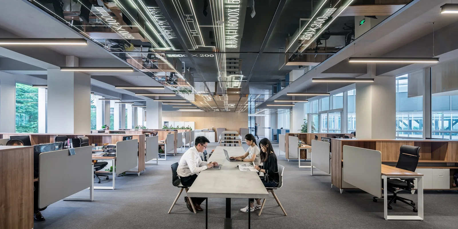 Team arbeitet gemeinsam an einem Tisch in einem modernen Großraumbüro