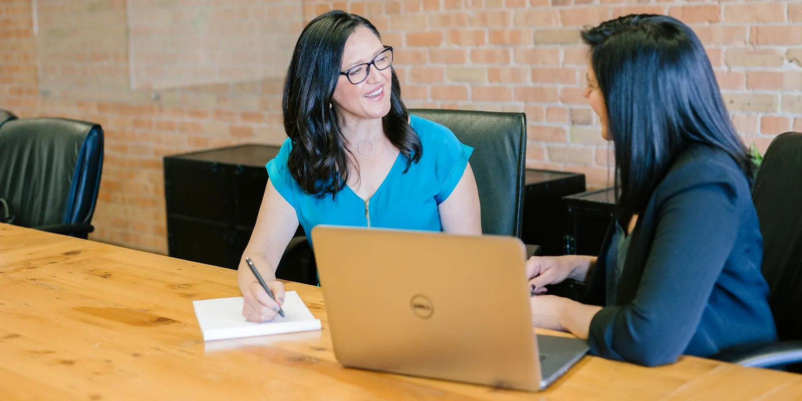 CRM marketing for e-commerce: two colleagues at a table with laptop and notepad