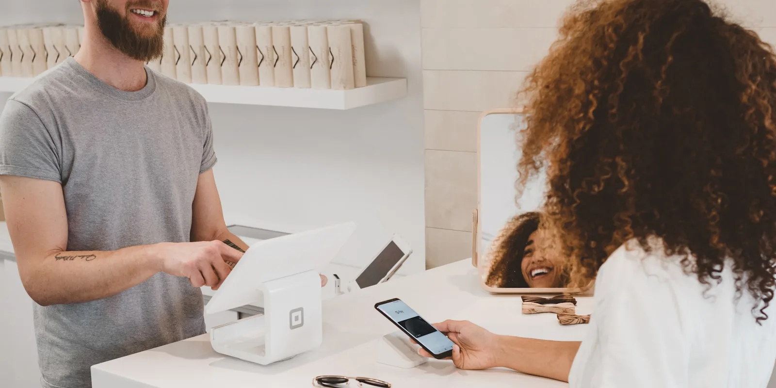 Kundin bezahlt im Ladengeschäft kontaktlos mit dem Smartphone